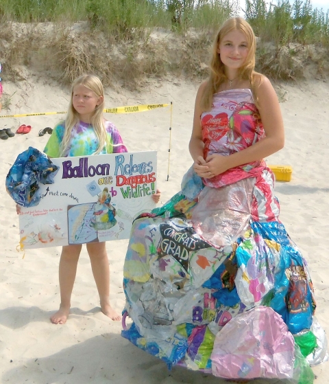A girl wears a dress made of salvaged balloon scraps.