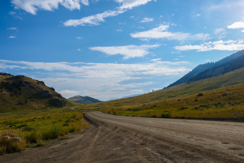 Dirt road winding through a green hills.