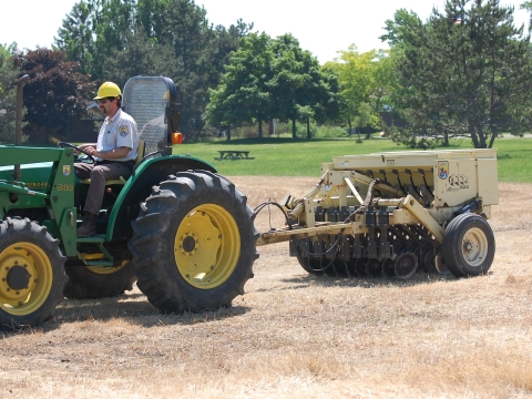 a construction vehicle drives across an empty field