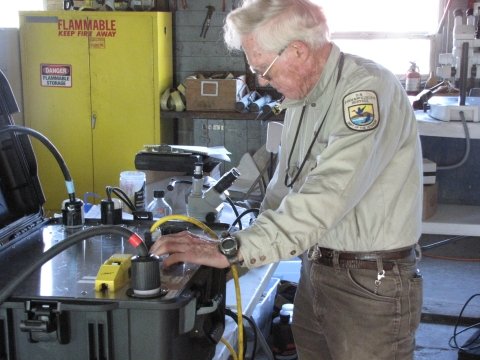 Kurt Steinke, an Electronics Engineer with the Abernathy Fish Technology Center adjusts an electroshocker's current and broadcast range as part of a study to control common carp densities at Malheur NWR Lake.