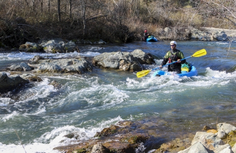 a man kayaks down a river in rapids