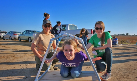 A group of girls smiling and playing on a nesting platform