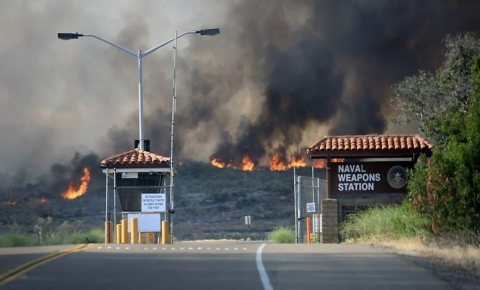 A fire burns in the hills behind the Naval Weapons Station guard gate.