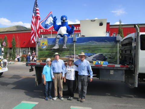 Image of volunteers standing in front of the fish stocking truck at a parade