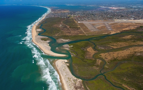An aerial view showing conserved refuge lands and waters next to highly developed suburban and urban communities