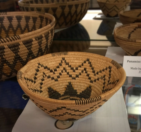 Multiple brown baskets with black woven designs on a table.