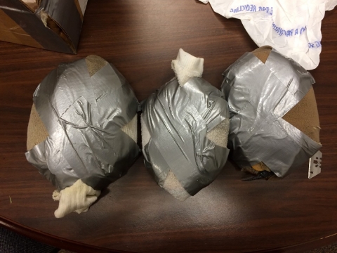 three large oval objects wrapped individually in socks and duct tape