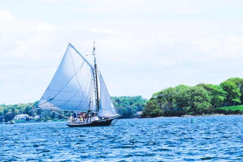 Sailboat crosses bay under full sail