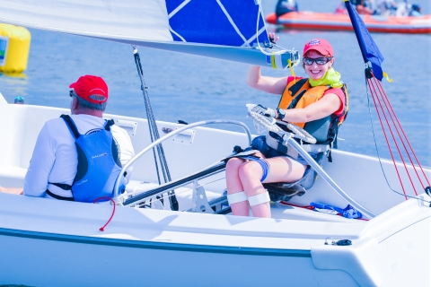 Handicapabale individual operates a sailboat across the bay