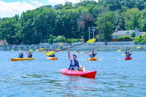 Kayakers lift paddles above their heads