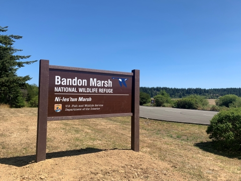 Welcome sign at the Ni-les'tun Parking lot on North Bank Lane.
