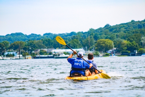 Two men kayak across the bay 