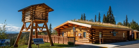 wooden visitor center with spruce trees in the background