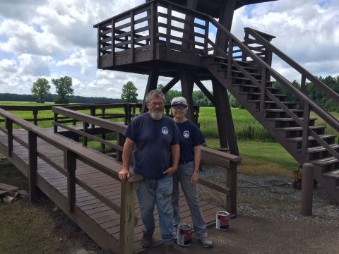 Two volunteers who just painted a viewing tower.
