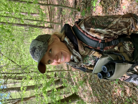 a woman dressed in camouflage in the woods