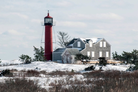 a snowy building with a tall red lighthouse