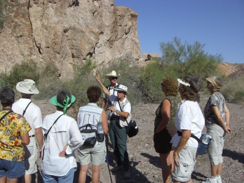 Volunteers Betty and Chuck Mulcahy lead an interpretive hike past cliffs at Imperial National Wildlife Refuge.