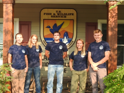 Five volunteers smiling in front of a refuge office.