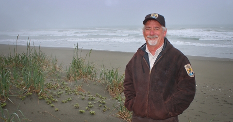 a man posing for a photo on the beach