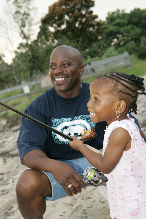 A young girl learns to fish.
