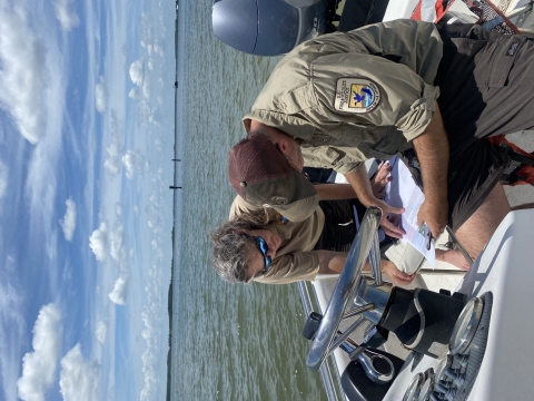 US Fish Wildlife Service staff surveying in motor boat
