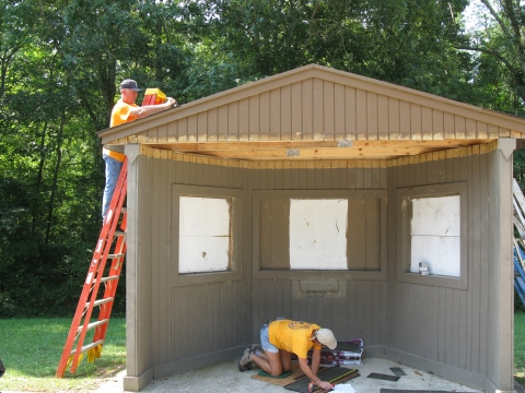 Volunteers doing construction on a kiosk.