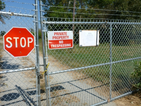 Closed fence with 'stop' and 'private property' signs