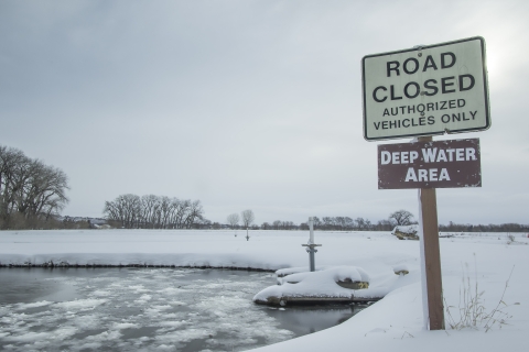 A road closed next to an icy pond.