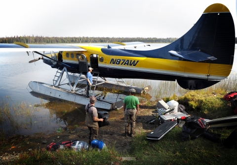 float plane with biologists and gear by a lake