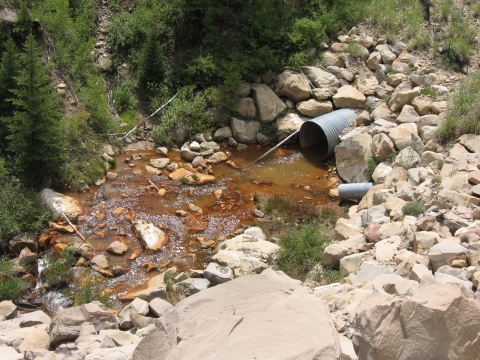 A stream with contaminants in the water near a mining operation. 