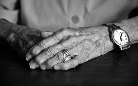 a close up black and white photo of an elderly woman's hands
