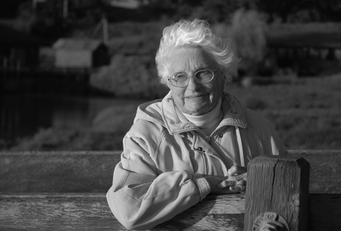 a black and white photo of an elderly woman outside