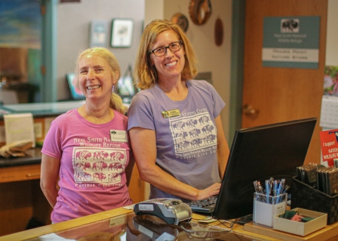 Two volunteers standing at the front desk