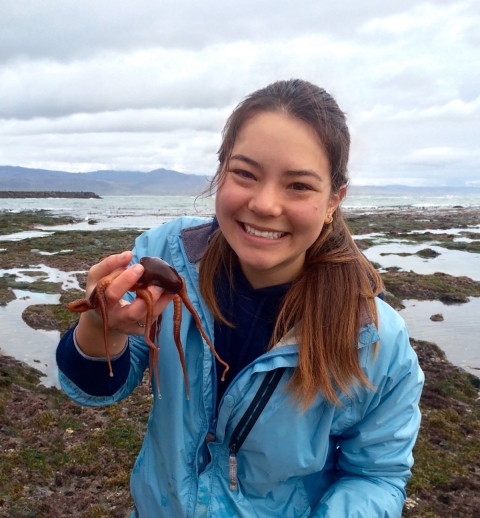 A woman in a blue jacket holding a small octopus