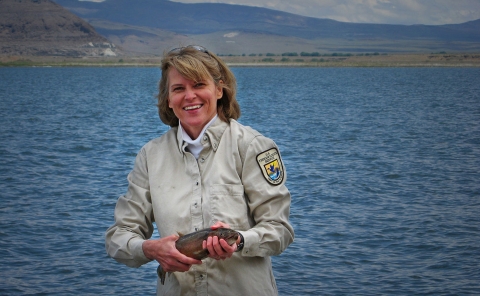 a woman holding a large fish