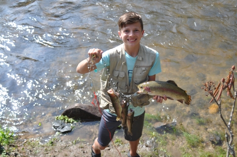 Youth with rainbow trout caught in Rock Creek at Chattahoochee Forest National Fish Hatchery 