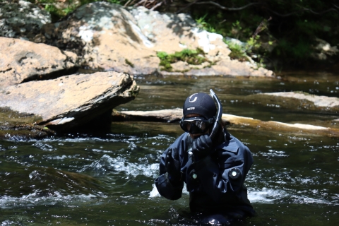 Biologist Martha Zapata in full dry suit about to enter the water to snorkel
