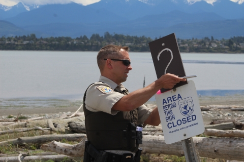 Zone Officer D. Huckel Installs Closed Area Sign On Dungeness Spit
