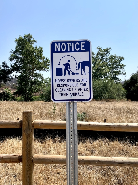 Refuge sign that reads "Notice, horse owners are responsible for cleaning up after their animals"