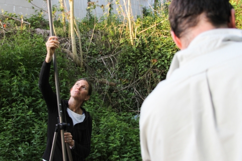 Woman standing in the woods holding a harp trap to catch bats.