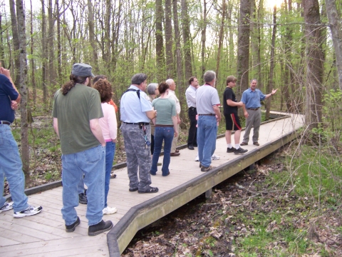 Group standing on boardwalk listening to guide