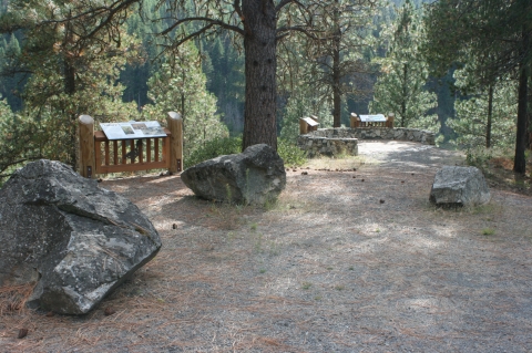 Scenic viewpoint along an auto tour, includes three interpretive panels. Located in an area with mature pine trees.