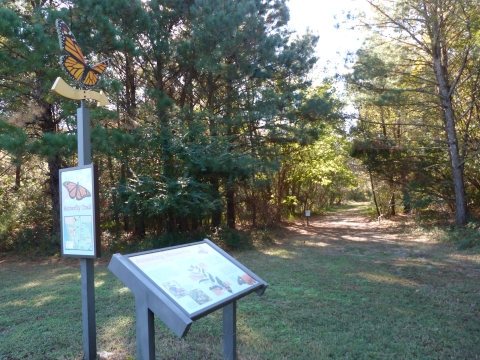 A directional arrow and interpretive signs with the trails stretching into the background
