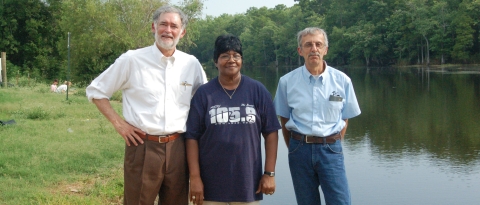 Refuge volunteers, two men and a woman standing next to the bayou