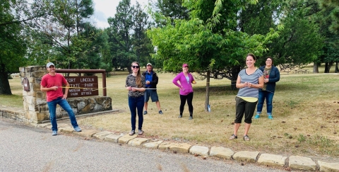 Six staff members from North Dakota Ecological Services standing six feet apart in a grassy area