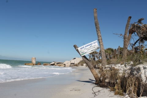 Save Egmont Key sign tied to dead trees on eroding beach line 