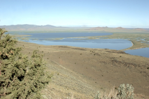 Looking out and down across an arid landscape toward a lake