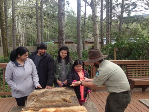 Oregon State Parks employee shows visitors some furs to touch