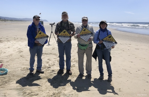 Volunteers place signs about sensitive nesting habitat for western snowy plovers