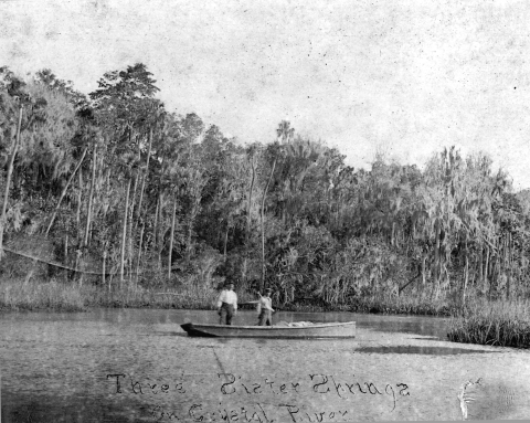Historic image of Three Sisters Springs and two men on a boat 